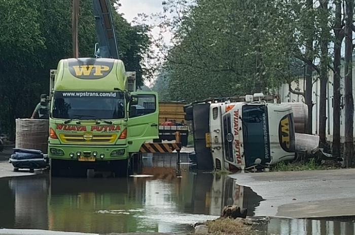 Foto: kondisi truk yang terguling usai sepeda jalan di tepi drainase Kawasan Industri Olek, Balaraja, amblas gegera banjir | Dok. Istimewa