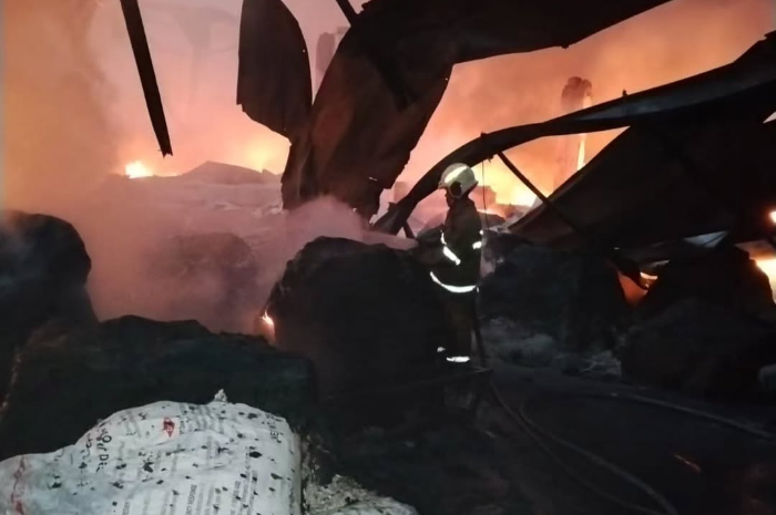 Foto: seorang petugas pemadam berusaha memadamkan api kebakaran pabrik sandal jepit di Tanah Tinggi | Dok. Istimewa