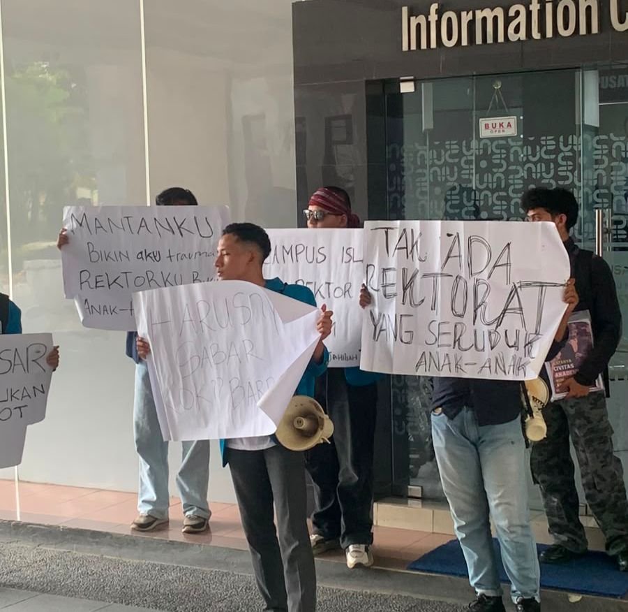 Tangerangupdate.com – Aliansi mahasiswa Universitas Islam Negeri (UIN) Syarif Hidayatullah Jakarta menggelar aksi demonstrasi damai di lingkungan kampus. Aksi ini merupakan buntut dari insiden ketegangan yang terjadi saat pihak rektorat melakukan visitasi ke Sekolah Islam Madrasah Pembangunan di Pamulang, Tangerang Selatan, pada Kamis (4/6/2026) lalu. Dalam aksi tersebut, mahasiswa membentangkan sejumlah poster bernada kritik tajam, di antaranya bertuliskan "Guru Besar itu main otak bukan otot!", "Kampus Islam tapi Rektor Pra-Islam", dan "Tak ada rektorat yang seruduk anak-anak". Kronologi Sengketa dan Ketegangan di Lapangan Ketegangan bermula ketika puluhan perwakilan dari pihak UIN Jakarta mendatangi Sekolah Islam Pembangunan saat kegiatan belajar mengajar sedang berlangsung. Pihak kampus mengklaim kedatangan tersebut sebagai agenda visitasi resmi berdasarkan legalitas administratif pencatatan aset sebagai Barang Milik Negara (BMN) per 13 Mei 2026, serta tindak lanjut atas rekomendasi BPK dan Inspektorat Jenderal. Namun, kedatangan tersebut direspons sebagai bentuk "penyerbuan" oleh pihak Yayasan Syarif Hidayatullah (YSH). Upaya penutupan gerbang sekolah memicu aksi saling dorong yang berujung pada robohnya pagar besi, hingga aparat TNI dan Polri terpaksa diturunkan untuk meredakan situasi. Insiden ini dilaporkan menyisakan trauma mendalam bagi siswa-siswi yang berada di lokasi. Aksi mahasiswa yang semula direncanakan berupa orasi di depan rektorat sempat diupayakan untuk dihentikan oleh pihak keamanan kampus. Pihak keamanan berdalih bahwa narasi yang beredar di media tidak sesuai dengan realitas lapangan, di mana oknum dari pihak UIN diklaim justru menjadi korban pemukulan terlebih dahulu. Demi menjaga kondusifitas, mahasiswa akhirnya menggeser lokasi aksi ke area lain di dalam kampus untuk melanjutkan diskusi dan membagikan selebaran aksi. "Aksi ini merupakan aksi damai. Ini bukan karena kami membenci UIN, akan tetapi sebaliknya, karena kami mencintai UIN. Kami hanya ingin mengingatkan," ujar salah satu perwakilan mahasiswa. Senin (08/06). 3 Tuntutan Utama Mahasiswa kepada Rektor UIN Jakarta Melalui seruan moral ini, mahasiswa mendesak kepemimpinan tertinggi kampus untuk mengambil langkah progresif dan humanis, dengan menyampaikan tiga tuntutan utama. "Hentikan Tindakan Lapangan Sepihak: Meminta rektorat menghentikan segala bentuk eksekusi atau pergerakan massa di lapangan selama proses hukum di PTUN dan Pengadilan Negeri masih berjalan aktif demi menghormati supremasi hukum," tegasnya. Permintaan Maaf Terbuka. Menuntut Rektor UIN Jakarta menyampaikan permohonan maaf secara terbuka kepada anak-anak, wali murid, dan pihak sekolah yang terdampak trauma akibat insiden 4 Juni. Restorasi Fasilitas dan Edukasi Etika: Menuntut pertanggungjawaban atas kerusakan fasilitas fisik sekolah yang rusak akibat gesekan, serta mendesak penegakan etika dan adab dalam berdemonstrasi maupun penyelesaian konflik. Sorotan Konflik Kepentingan dan Prosedur Hukum Mahasiswa juga mengkritisi dasar hukum tindakan rektorat. Keputusan Menteri Agama (KMA) No. 1543/2025 yang dijadikan landasan dinilai hanya mengamanatkan tiga hal, inventarisasi, reviu pejabat Kemenag, dan serah terima resmi bukan tindakan pemaksaan di lapangan. Selain itu, keterlibatan mantan Rektor UIN, Dede Rosyada yang pada Maret 2026 lalu sempat dimintai keterangan oleh Kejaksaan Tinggi Banten. Terkait dugaan korupsi pengelolaan aset negara sejak 2004 turut memicu kritik tajam mengenai adanya potensi konflik kepentingan (conflict of interest) dalam penanganan sengketa aset ini. "Jelas adanya konflik kepentingan terkait ricuhnya penanganan sengketa ini, karena ada rektor yang tidak menjabat ikut turut serta" pungkasnya.