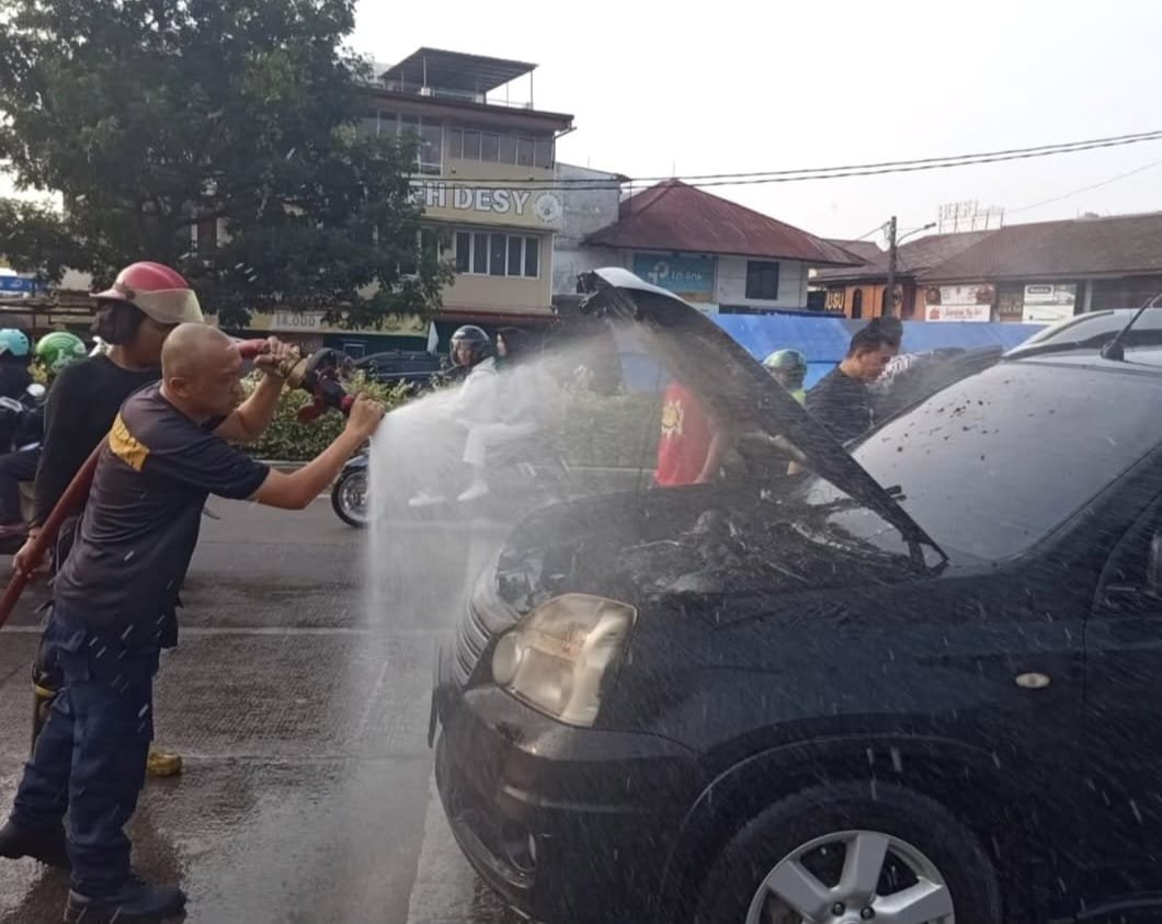 Petugas Pemadam kebakaran melakukan pemadaman api yang muncul dari mesin mobil / Dok. TU